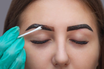 Master corrects makeup, it gives shape and color the eyebrows henna in a beauty salon, Spa. Professional skin care.